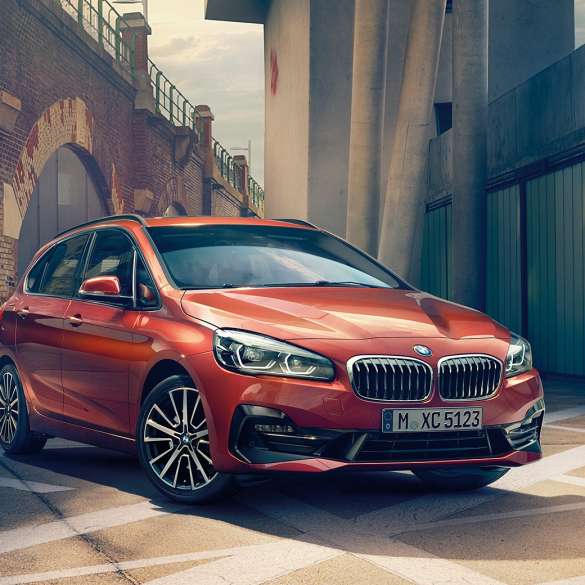 Exterieur BMW 2er Active Tourer F45 BMW 2er Active Tourer F45 Facelift 2018 Sunset Orange metallic Dreiviertel-Frontansicht parkend in Gasse