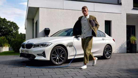 Plug-in-Hybrid BMW 3er Limousine 2021 G20 Dreiviertel-Frontansicht ladend Plug-in-Hybrid BMW 3er Limousine 2021 G20 Dreiviertel-Frontansicht ladend mit Model