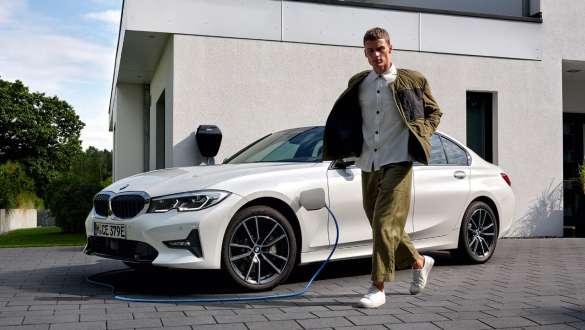 Plug-in-Hybrid BMW 3er Limousine 2021 G20 Dreiviertel-Frontansicht ladend Plug-in-Hybrid BMW 3er Limousine 2021 G20 Dreiviertel-Frontansicht ladend mit Model