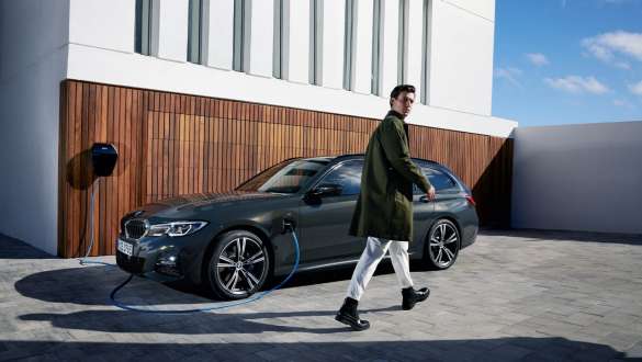 Plug-in-Hybrid BMW 3er Touring 2021 G21 Dreiviertel-Seitenansicht ladend Plug-in-Hybrid BMW 3er Touring 2021 G21 Dreiviertel-Seitenansicht ladend mit Model
