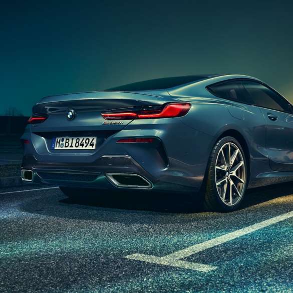 BMW 8er Coupé, Dreiviertel-Heckansicht. BMW 8er Coupé, Dreiviertel-Heckansicht, Standaufnahme vor nächtlicher Kulisse.