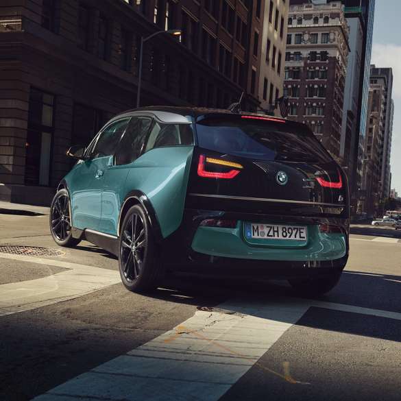 BMW i3 2018 Dreiviertel-Heckansicht fahrend I01 BMW i3 I01 2018 Jucarobeige mit Akzent Frozen Grey metallic Dreiviertel-Heckansicht fahrend in urbaner Kulisse