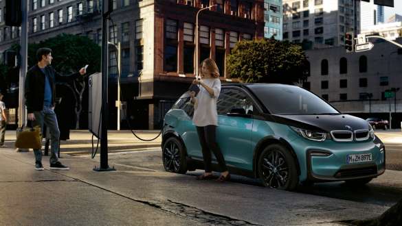 BMW i3 I01 2018 an einer öffentlichen Ladestation Paar lädt seinen BMW i3 an einer öffentlichen Ladestation I01 2018 Blue Ridge Mountain mit Akzent Frozen Grey metallic