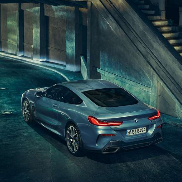 BMW M850i xDrive Coupé, Dreiviertel-Heckansicht links. G15 BMW M850i xDrive Coupé in Barcelona Blau metallic, Dreiviertel-Heckansicht links, stehend bei Nacht. G15