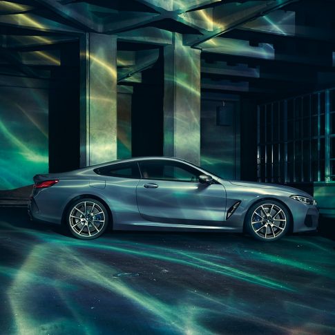 BMW M850i xDrive Coupé, Seitenansicht. G15 BMW M850i xDrive Coupé in Barcelona Blau metallic, Seitenansicht, stehend vor Gebäude. G15