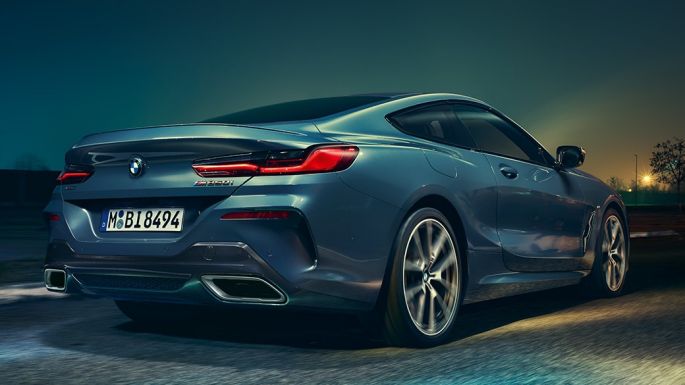 BMW M850i xDrive Coupé, Heckansicht. G15 BMW M850i xDrive Coupé in Barcelona Blau metallic, Heckansicht, fahrend bei Nacht. G15