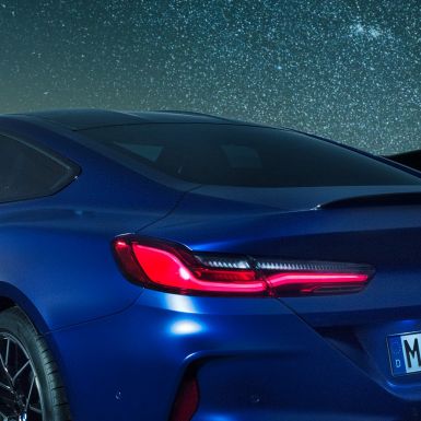 M Heckspoiler. F92 BMW M8 Competition Coupé in Marina Bay Blau metallic, nächtliche Nahaufnahme Schulterpartie mit M Heckspoiler aus Carbon. F92
