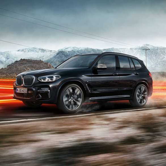 BMW X3 M40i und BMW X3 M40d SUV, Seitenansicht. BMW X3 M40i und BMW X3 M40d SUV in Saphierschwarz metallic, fahrend, Exterieur, Seitenansicht vor Berglandschaft mit Lichtstreifen.