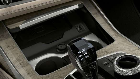 Temperierte Getränkehalter des BMW X7 M Automobils BMW X7 M Automobil, Interieur, Nahaufnahme der Mittelkonsole mit Fokus auf die temperierten Getränkehalter, G07