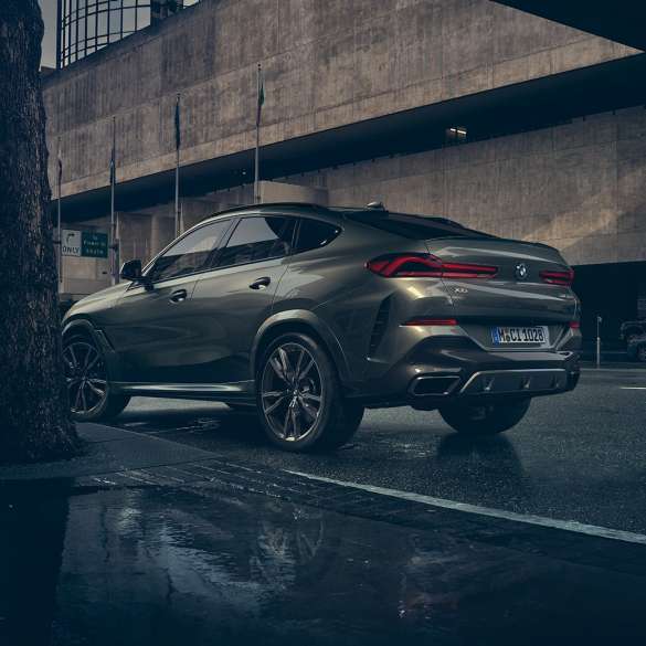 BMW X6 Exterieur. G06 BMW X6 in Dreiviertel-Heck-Perspektive vor urbaner Kulisse. G06