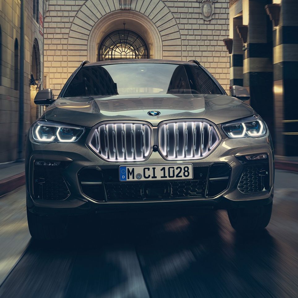 BMW X6 mit BMW Niere ‘Iconic Glow’. G06 BMW X6 in Frontansicht vor urbaner Kulisse. G06