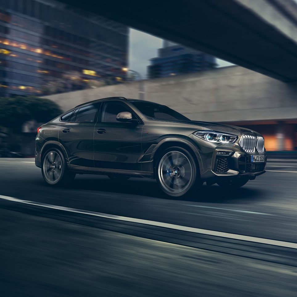 BMW X6 driving. G06 BMW X6 in Dreiviertel-Front-Perspektive fahrend vor urbaner Kulisse. G06