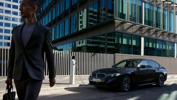 BMW Série 3 Berline Plug-in Hybrid G20 vue de trois quarts de profil en recharge BMW Série 3 Berline Plug-in Hybrid G20 vue de trois quarts de profil en recharge avec modèle