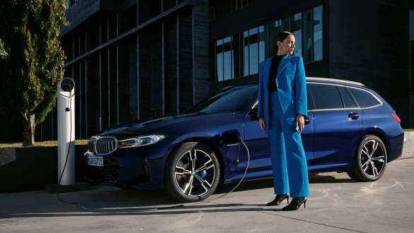 BMW Série 3 Touring Plug-in Hybrid G21 vue de trois quarts de profil en recharge BMW Série 3 Touring Plug-in Hybrid G21 vue de trois quarts de profil en recharge avec modèle
