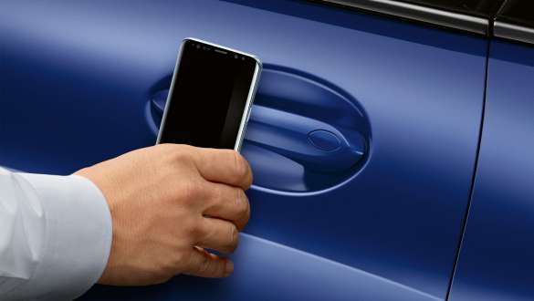 BMW Digital Key BMW Série 8 Coupé G15 LCI restylage 2022 BMW Digital Key BMW Série 8 Coupé G15 M Portimao Blau metallic LCI restylage 2022 main qui tient un smartphone devant la porte de la voiture