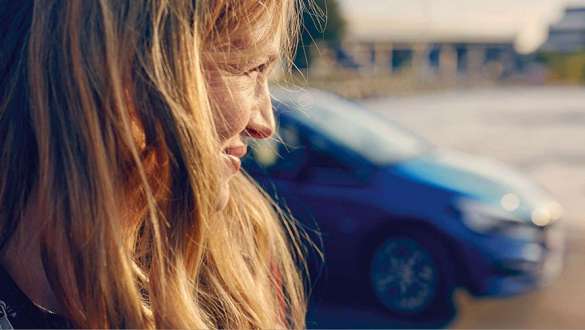Femme devant un concessionnaire BMW BMW Service Inclusive, femme devant un concessionnaire BMW