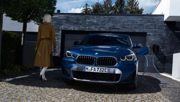 BMW X2 xDrive25e F39 hybride rechargeable, vue avant devant garage BMW X2 xDrive25e F39 hybride rechargeable, vue avant devant un garage avec modèle