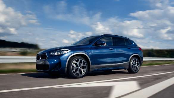 BMW X2 xDrive25e F39 hybride rechargeable, vue de trois quarts de profil en mouvement BMW X2 xDrive25e F39 hybride rechargeable, vue de trois quarts de profil en mouvement sur la route