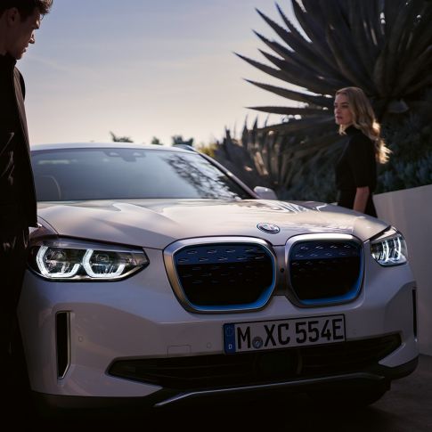 BMW iX3 SUV électrique G08, vue de trois quarts avant avec naseaux BMW i BMW iX3 SUV électrique G08 2020 en Mineralweiß metallic, vue de trois quarts avant avec naseaux BMW i