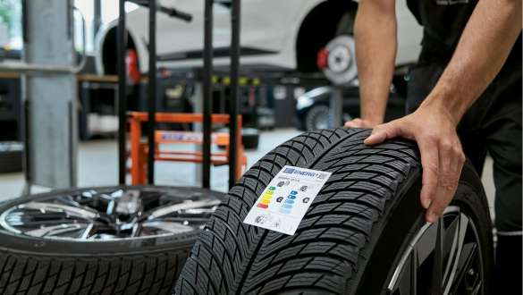My BMW App BMW reparaties en verzorging BMW reparaties en verzorging My BMW App vrouw met smartphone in de handen leunt tegen BMW wagen