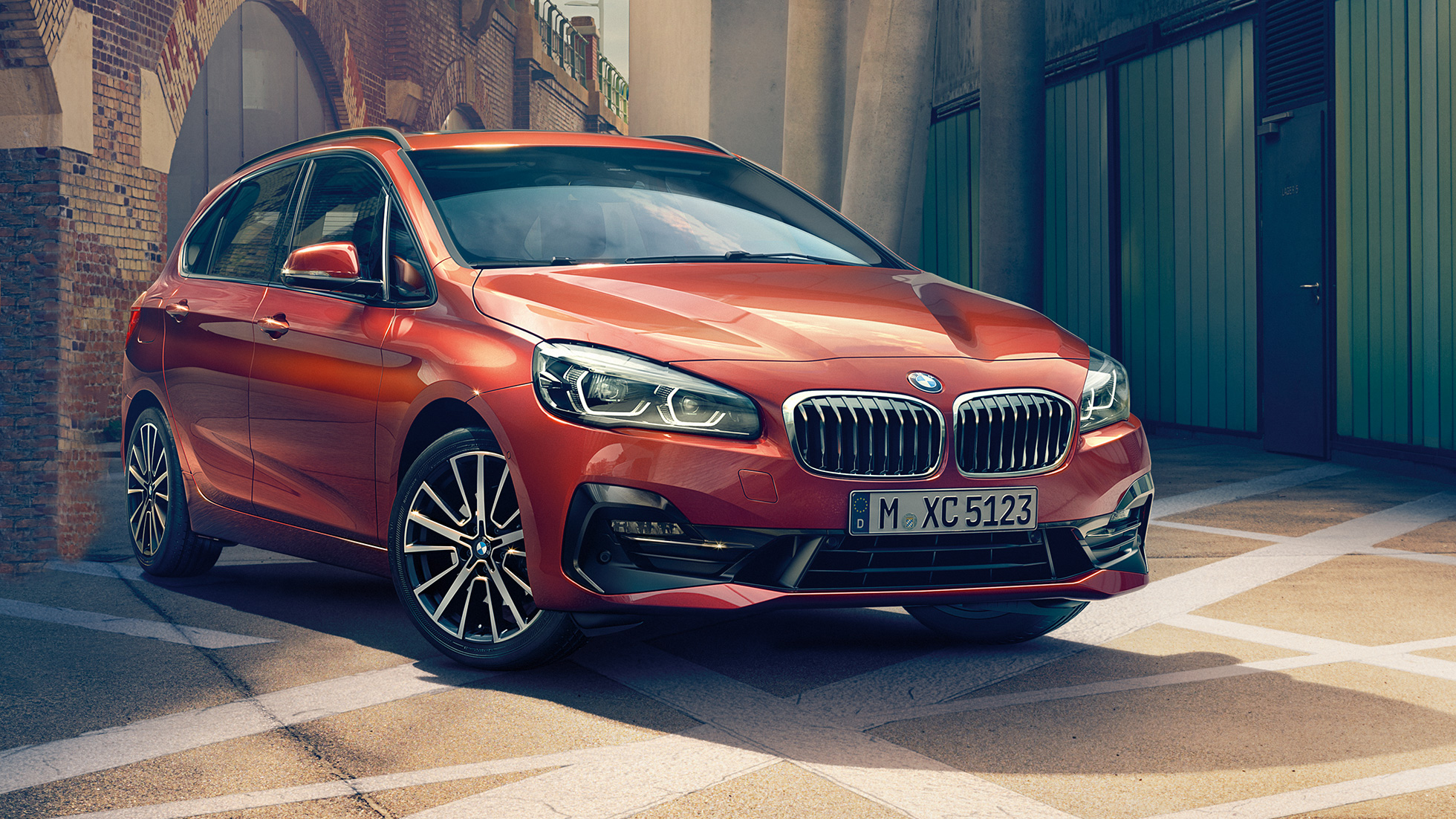 Exterieur BMW 2er Active Tourer F45 BMW 2er Active Tourer F45 Facelift 2018 Sunset Orange metallic Dreiviertel-Frontansicht parkend in Gasse