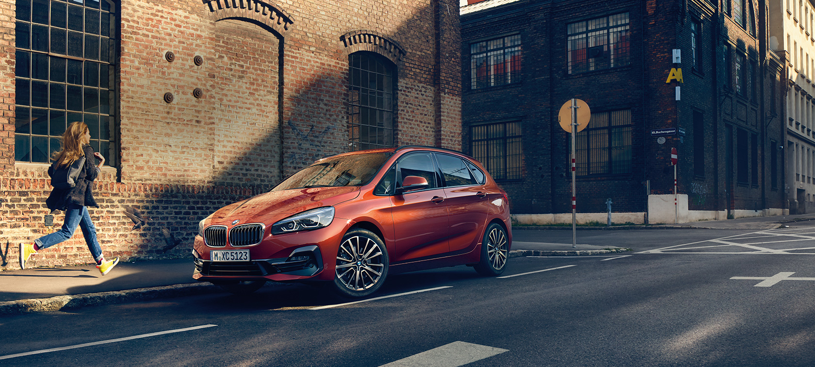 BMW 2er Active Tourer parkend F45 BMW 2er Active Tourer F45 Facelift 2018 Sunset Orange metallic Dreiviertel-Frontansicht parkend auf der Straße