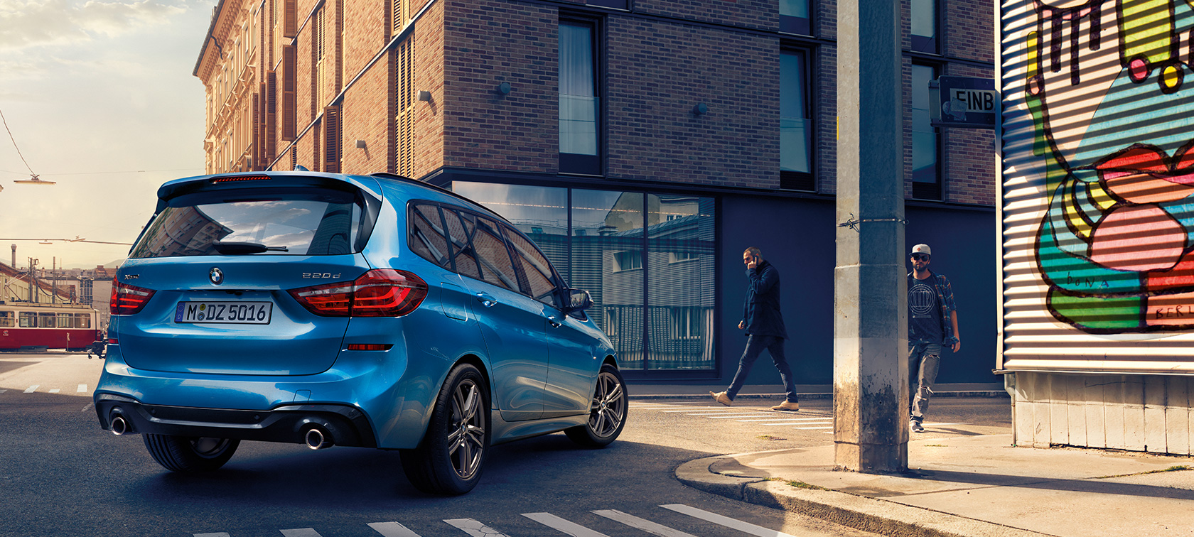 Mann neben BMW 2er Gran Tourer F46 Facelift 2018 Misano Blau metallic Vogelperspektive parkend auf Straße