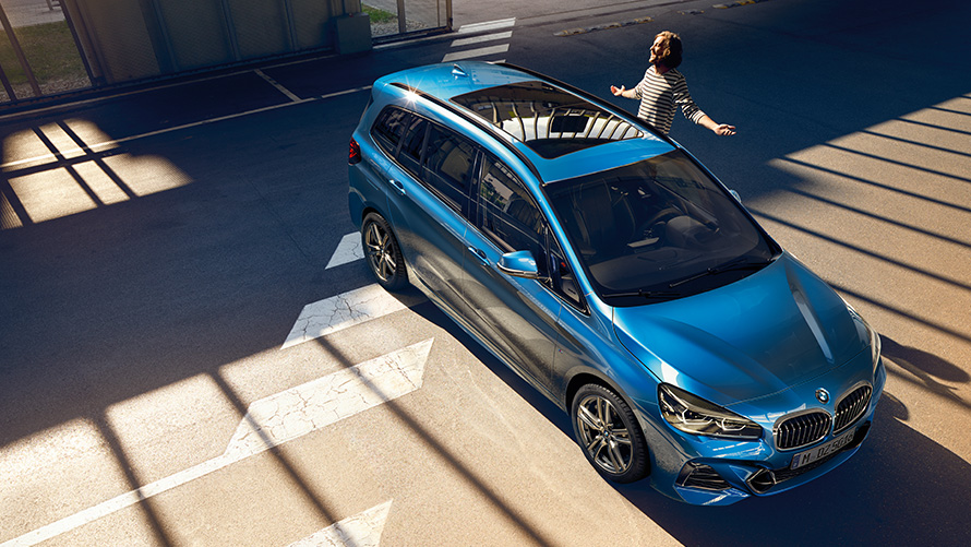 Famille à côté de la BMW Série 2 Gran Tourer F46 restylage 2018 Estoril Blau metallic 