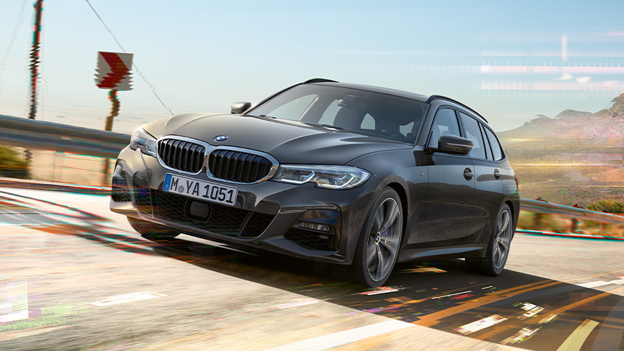 BMW 3er Touring (G21) Dravitgrau, Dreiviertel-Frontaufnahme BMW 3er Touring (G21) Dravitgrau, Dreiviertel-Frontaufnahme im Fahren in ländlicher Umgebung