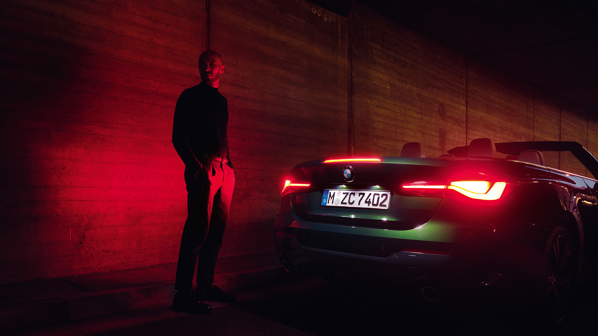 Vue de trois quarts arrière avec capote ouverte de la BMW Série 4 Cabrio G23 2020 BMW Série 4 Cabrio G23 2020 Sanremo Green metallic, vue de trois quarts arrière de nuit, avec capote ouverte
