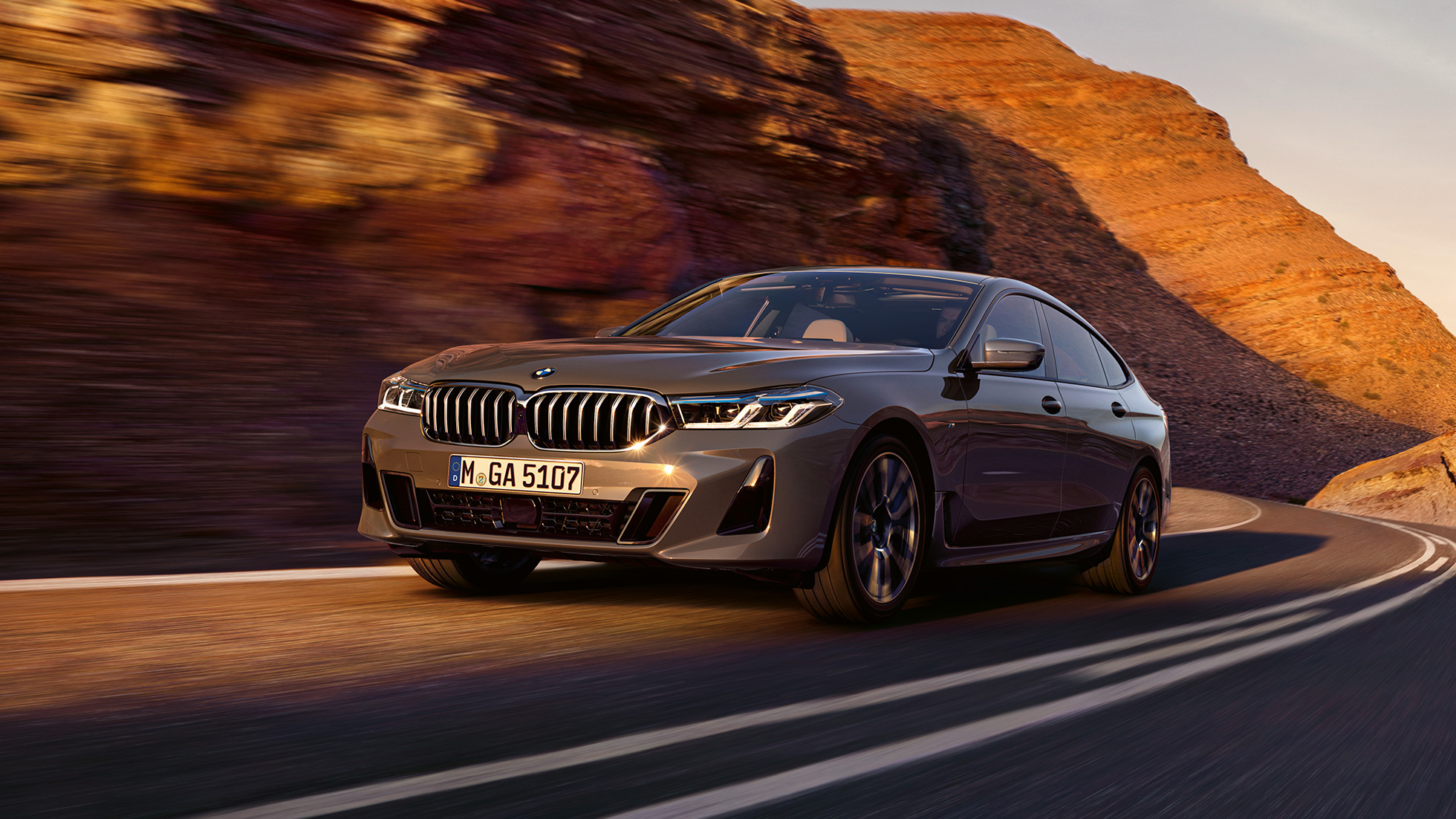 BMW 6er Gran Turismo G32 2020 BMW 6er Gran Turismo 640i xDrive G32 2020 Berninagrau Dreiviertel-Frontansicht fahrend auf Straße vor Landschaft