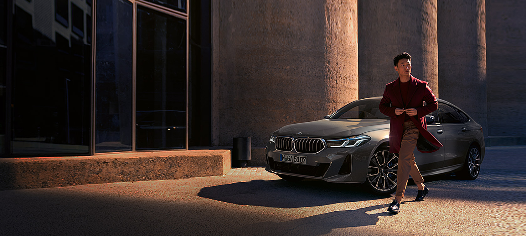 BMW Série 6 Gran Turismo 640i xDrive G32 2020 en Berninagrau, homme devant une BMW à l'arrêt, vue de trois quarts avant