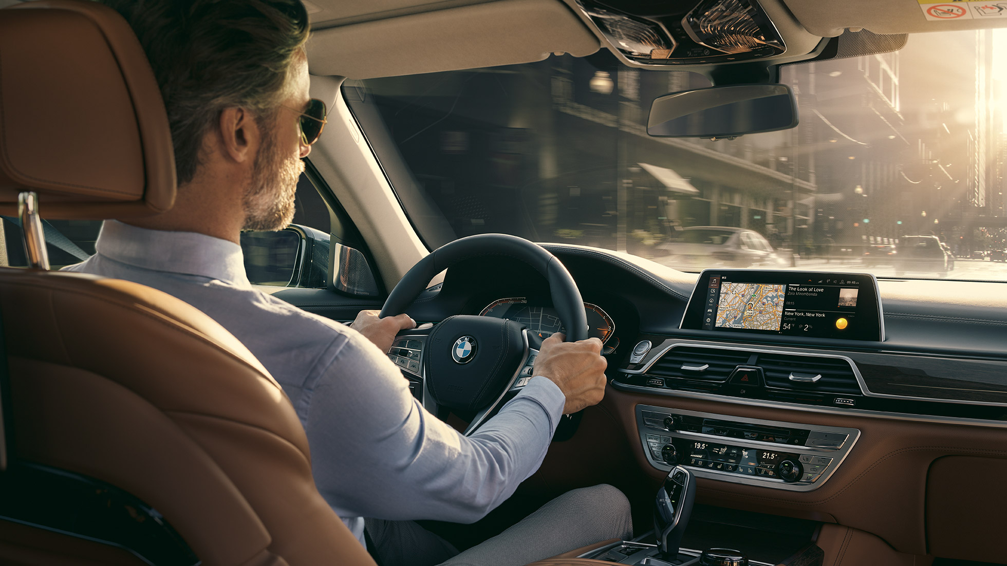 BMW 7er Connectivity Features G11 BMW 7er: Mann sitzt im BMW und nutzt Connectivity Features G11