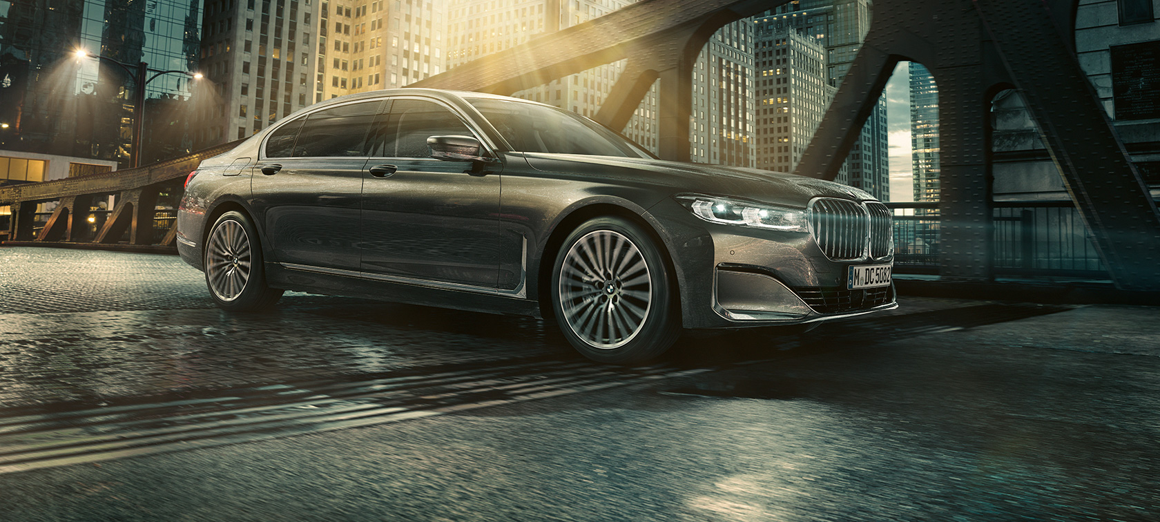 BMW Série 7 Berline, vue latérale G11 Vue latérale de la BMW Série 7 Berline avec portière ouverte devant un hôtel éclairé G11.