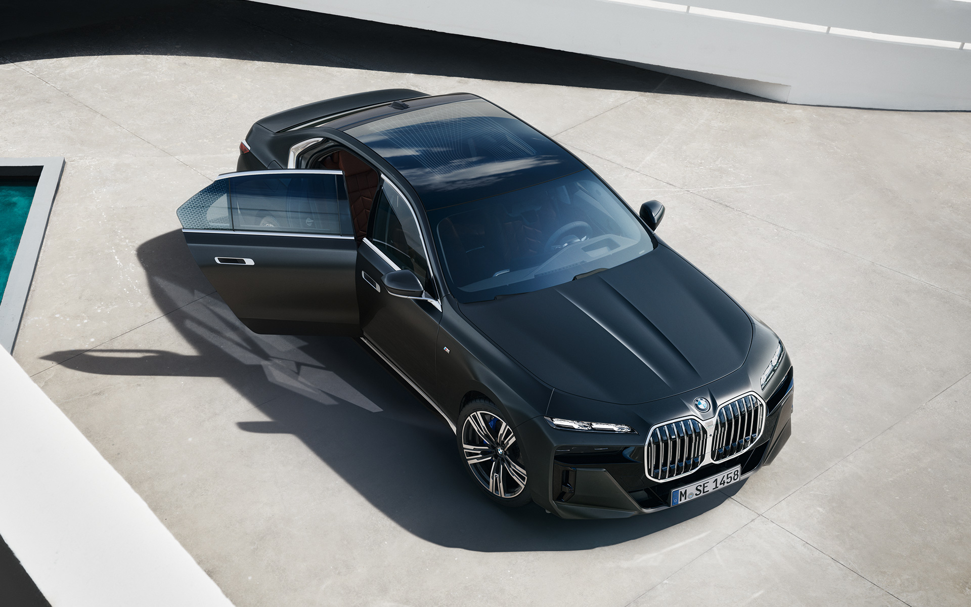 Vue en plongée BMW Série 7 Berline G70 ICE 740i kit M Sport Frozen Deep Grey metallic BMW Série 7 Berline G70 ICE 740i kit M Sport Frozen Deep Grey metallic vue en plongée avec portière arrière ouverte