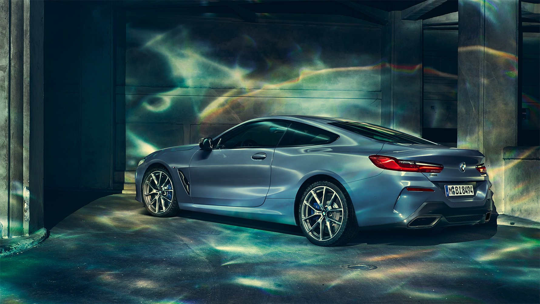 BMW 8er Coupé, Dreiviertel-Heckschuss Dreiviertel-Heckschuss des BMW 8er Coupé in der Nacht vor urbaner Kulisse.