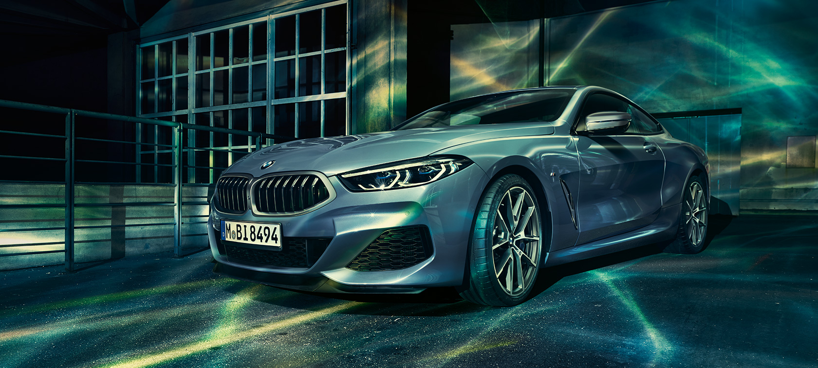 BMW 8er, Dreiviertel-Front Dreiviertel-Front-Standaufnahme des BMW 8er Coupé vor urbaner Kulisse.
