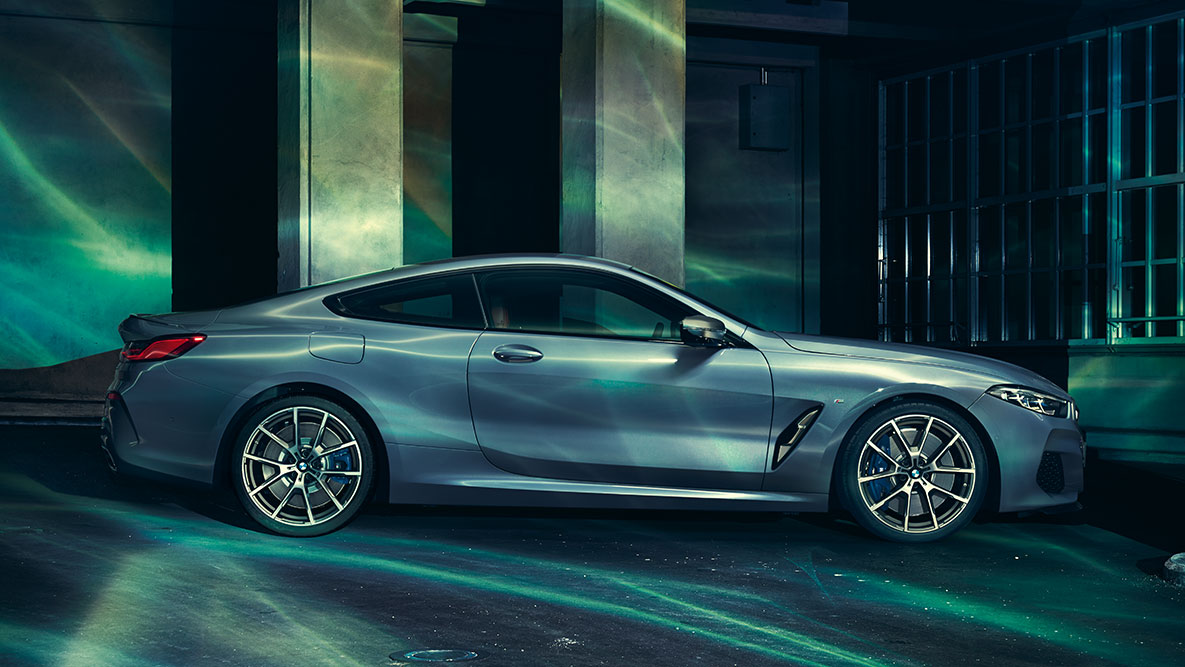 BMW 8er Coupé, Seitenansicht. Standaufnahme des BMW 8er Coupé aus seitlicher Perspektive vor urbaner Kulisse.