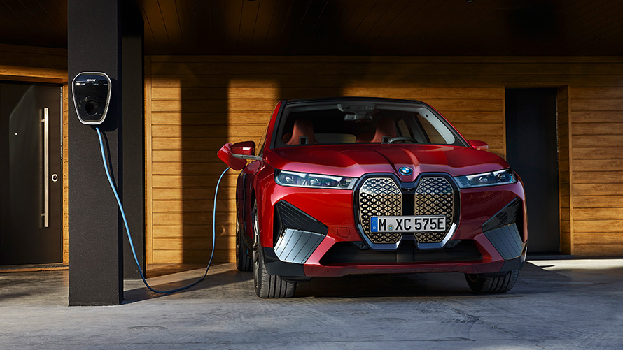 BMW iX i20 elektrischer SUV BMW iX xDrive50 Laden BMW iX i20 2021 elektrischer SUV BMW iX xDrive50 Aventurinrot an einer BMW Wallbox aufladen Laden