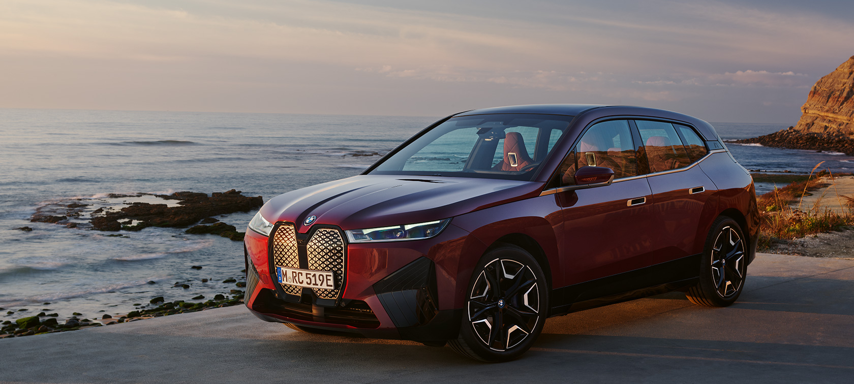 BMW iX i20 2021 SUV électrique BMW iX xDrive50 Aventurinrot devant le littoral