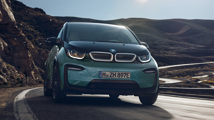 BMW i3 I01 2018 Blue Ridge Mountain avec accent Frozen Grey metallic vue de profil roulant dans un décor urbain