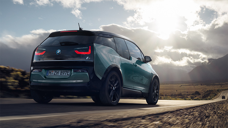 BMW i3 I01 2018 Blue Ridge Mountain avec accent Frozen Grey metallic vue de trois quarts arrière roulant sur une route de campagne