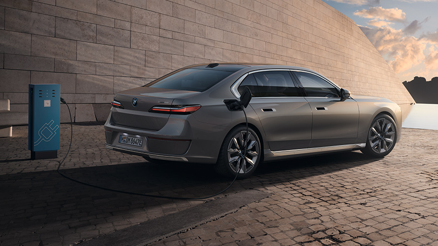 BMW i7 Berline G70 vue de trois quarts arrière BMW i7 Berline G70 BMW Individual Oxid grey metallic vue de trois quarts arrière à l’arrêt devant un bâtiment