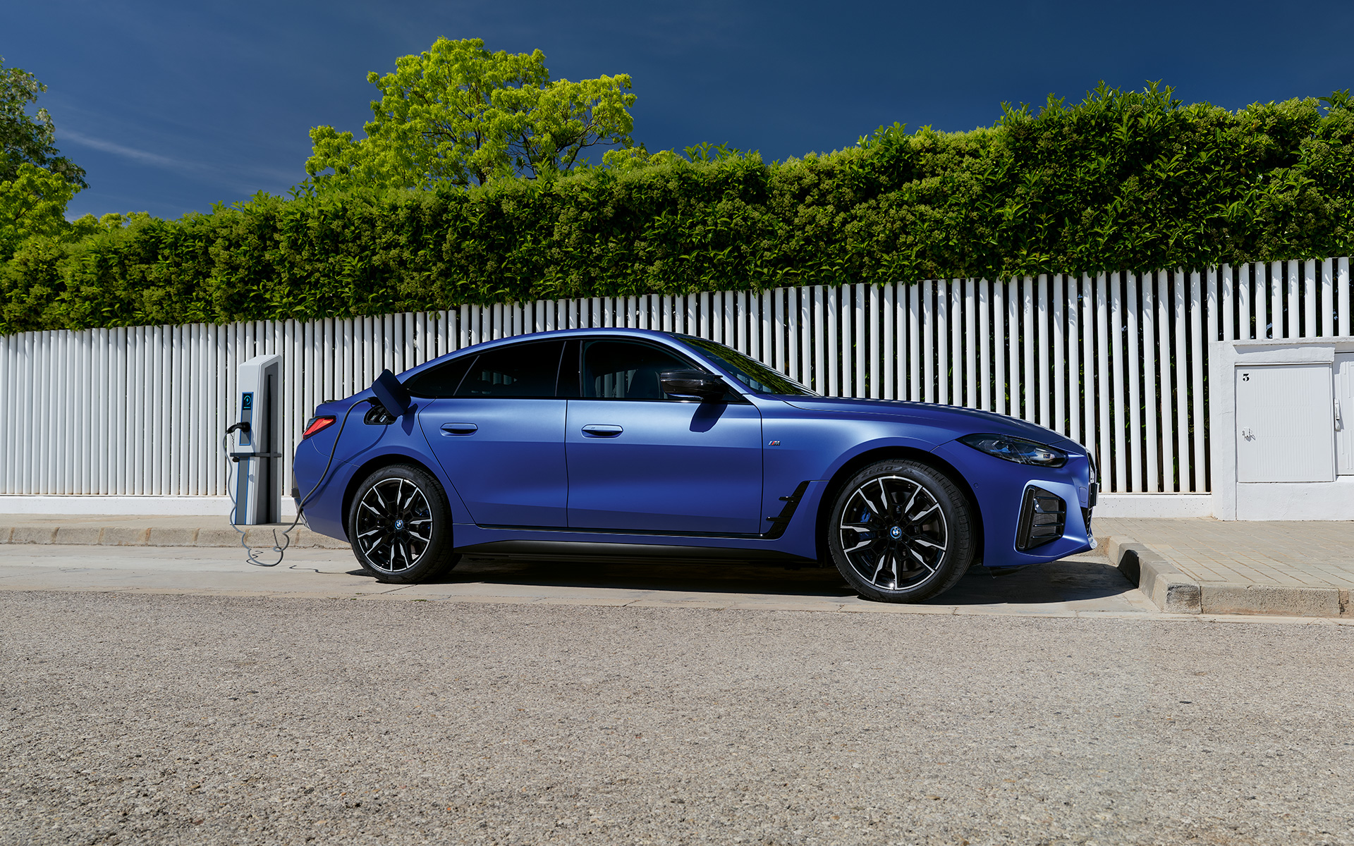 BMW i4 M50 G26 2021 BMW Individual Frozen Portimao Blau metallic Seitenansicht angeschlossen an Ladesäule