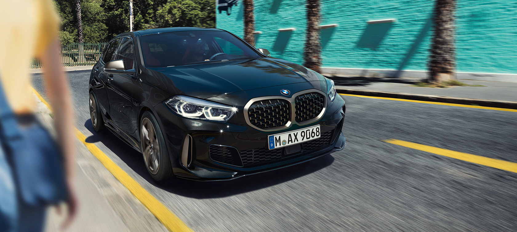 BMW M135i xDrive, Dreiviertel-Frontansicht F40. BMW M135i xDrive in Saphirschwarz metallic Dreiviertel-Frontansicht fahrend F40.