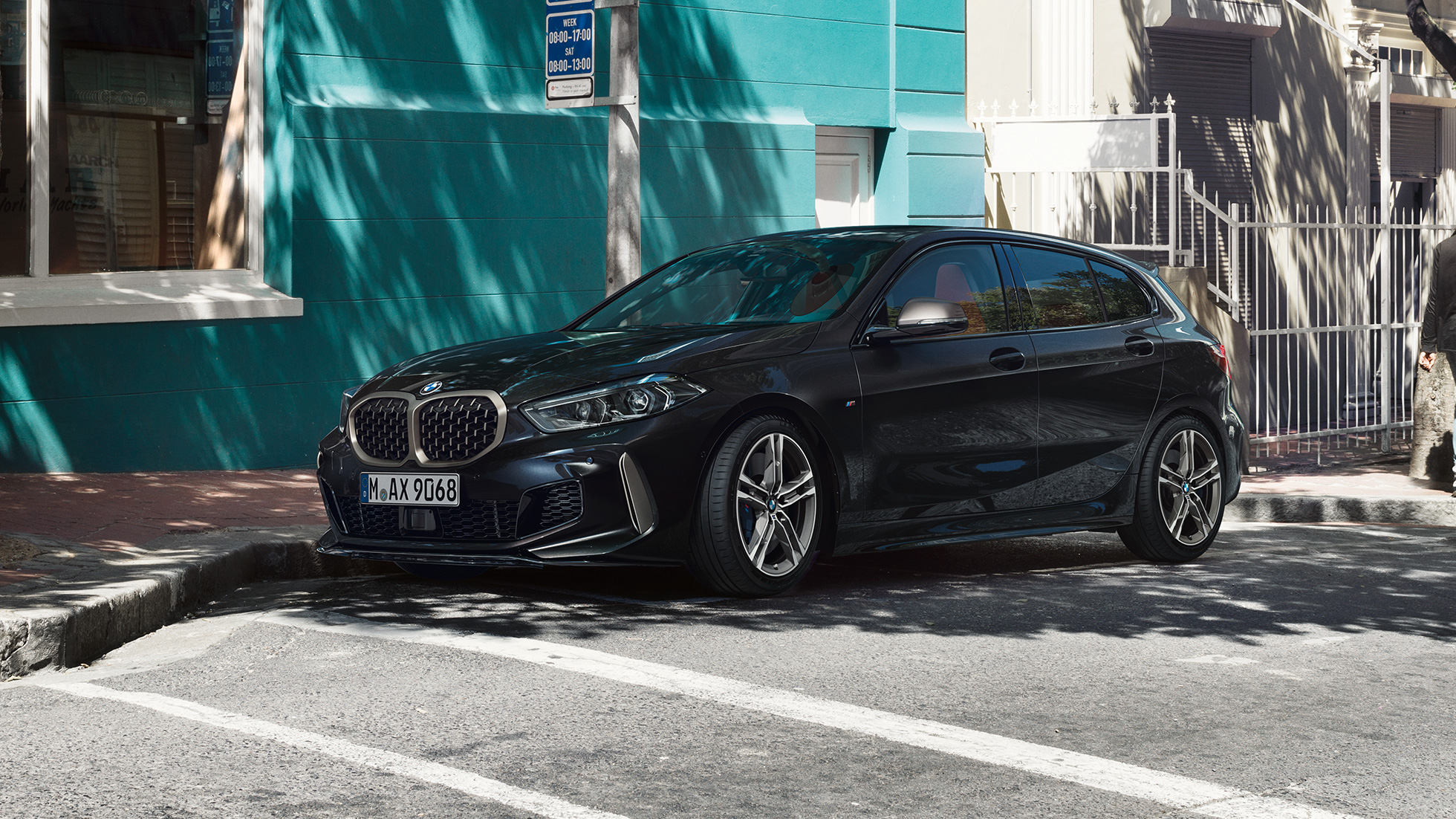 BMW M135i xDrive, Dreiviertel-Seitenansicht F40. BMW M135i xDrive in Saphirschwarz metallic, Dreiviertel-Seitenansicht parkend F40.