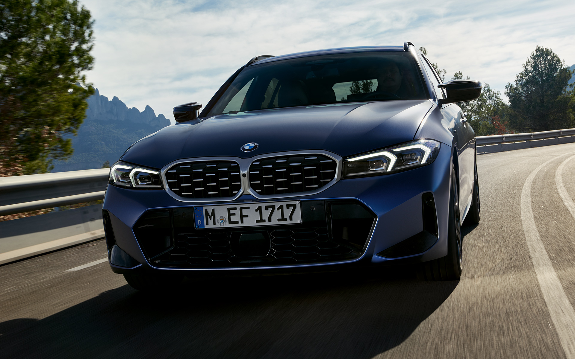 BMW M340i xDrive Touring G21 Frozen Tanzanite Blue Frontansicht fahrend auf Straße 