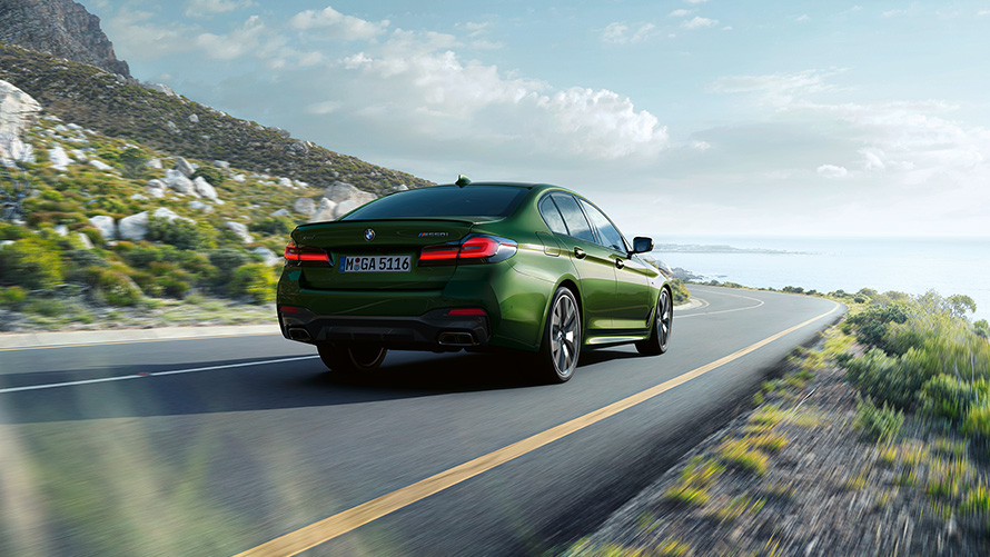 BMW M550i xDrive Limousine G30 LCI Facelift 2020 BMW Individual Verde Ermes metallic Dreiviertel-Heckansicht fahrend