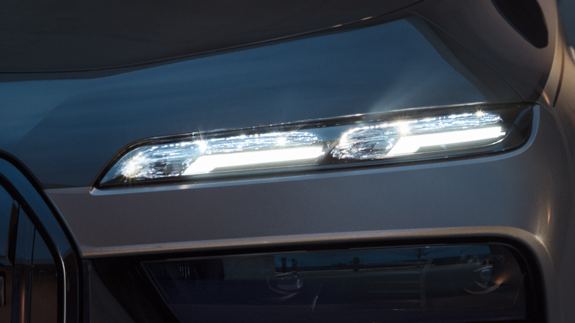 Phares cristal BMW Iconic Glow BMW M760e xDrive Berline G70 Phares cristal BMW Iconic Glow BMW M760e xDrive Berline G70 teinte bi-ton BMW Individual Saphirschwarz metallic BMW Individual Dravitgrau metallic vue en gros plan avec phares allumés