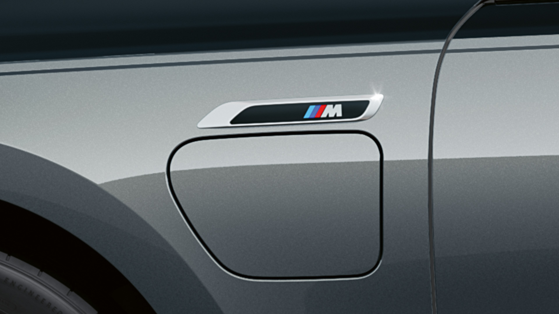 Badge M BMW M760e xDrive Berline G70 Badge M BMW M760e xDrive Berline G70 M Performance Pack teinte bi-ton BMW Individual Saphirschwarz metallic BMW Individual Dravitgrau metallic vue en gros plan de profil